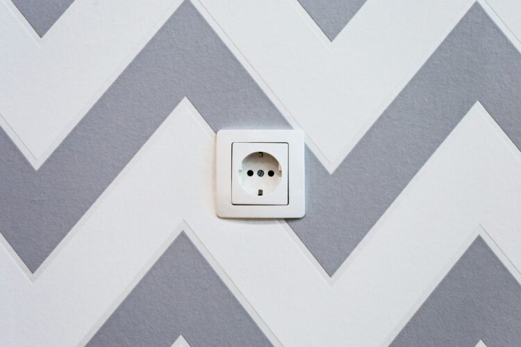White power strip mounted on white and grey chevron painted wall