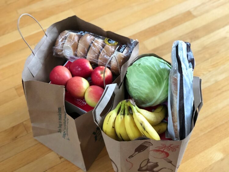 Apples and bananas in brown cardboard box