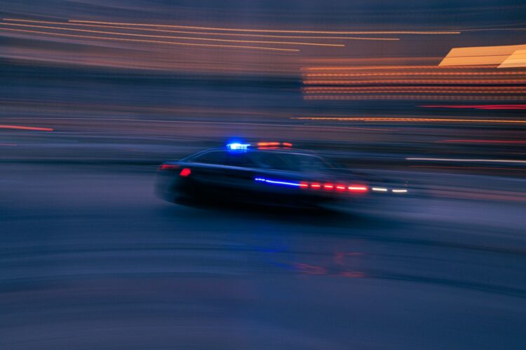 A police car driving down a street at night