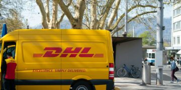man standing in front of DHL truck door