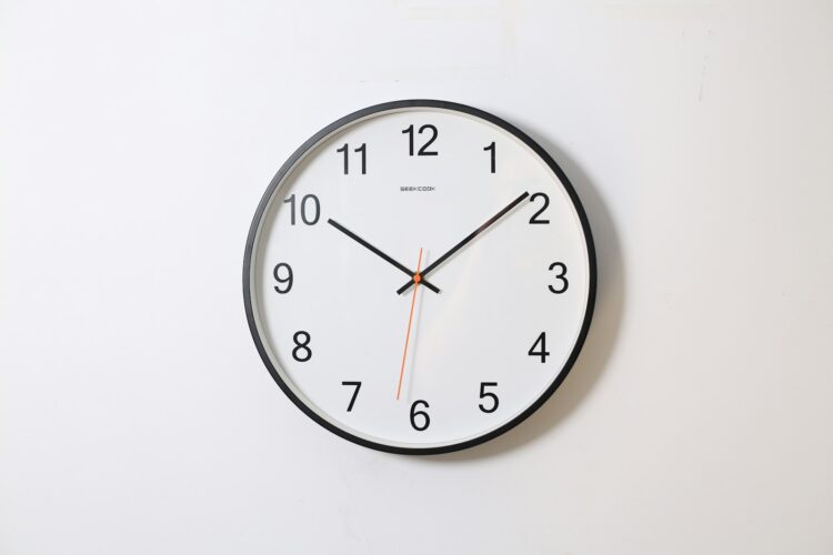 Round analog wall clock pointing at 1009