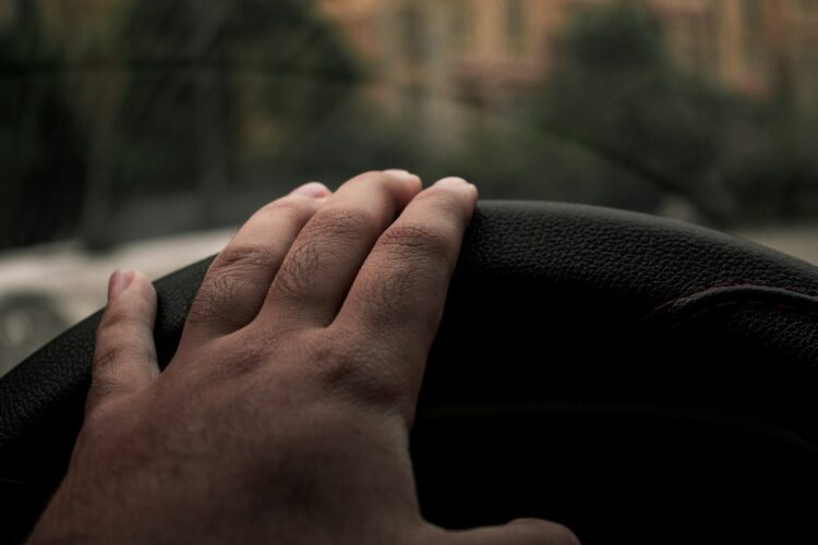 A person's hand on a leather chair