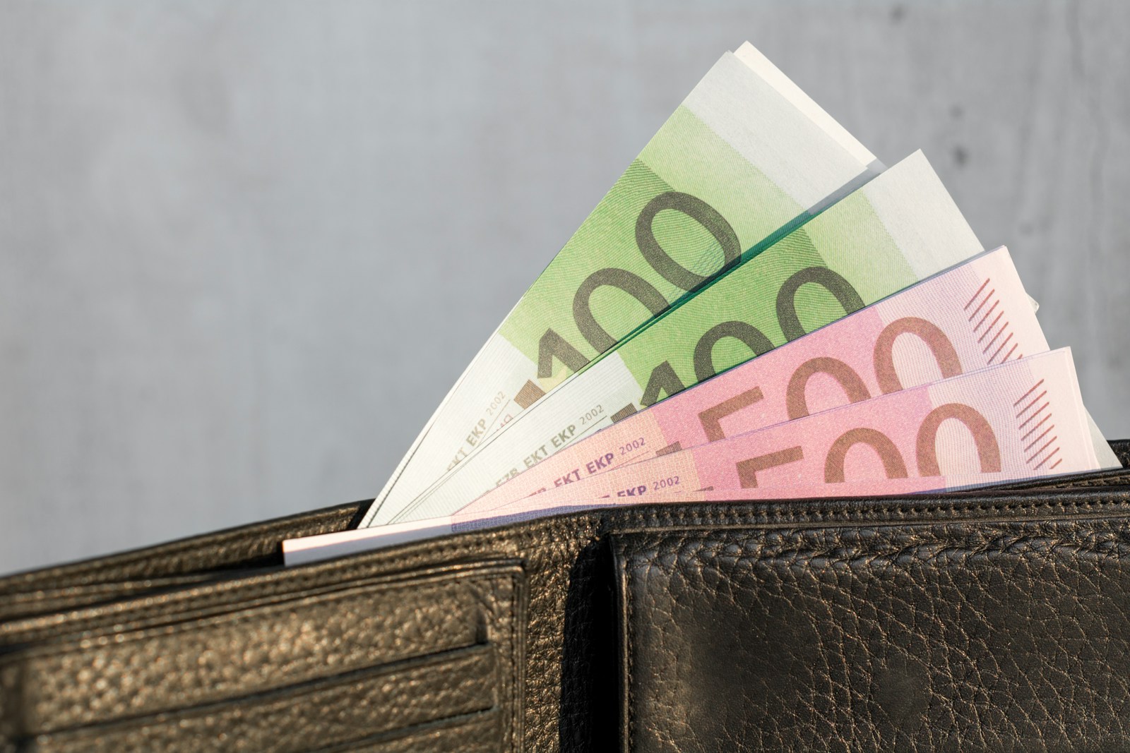 A wallet with a bunch of money sticking out of it