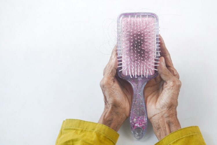 A person holding a hair brush in their hands