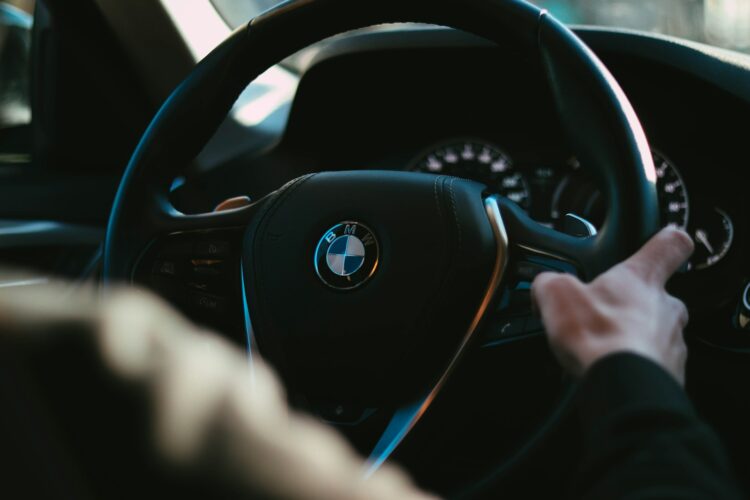 Person holding black bmw steering wheel