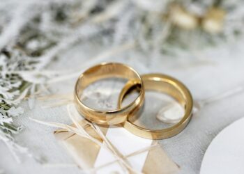 Gold wedding band on white textile