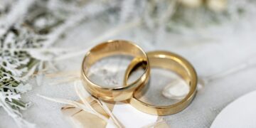 gold wedding band on white textile