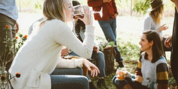 woman sitting near people while drinking