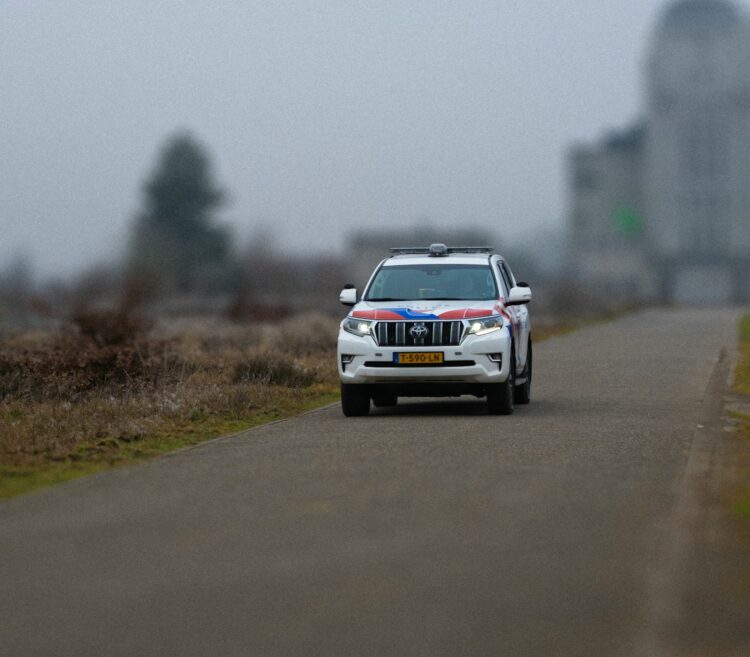 A white suv driving down a foggy road