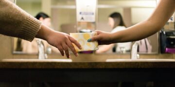 person holding white and blue ceramic mug