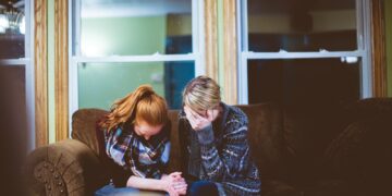 man and woman sitting on sofa in a room