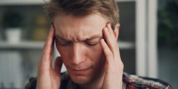 a man holding his hands to his ears