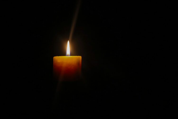 A single lit candle in the dark