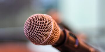 grey microphone on brown wooden stand