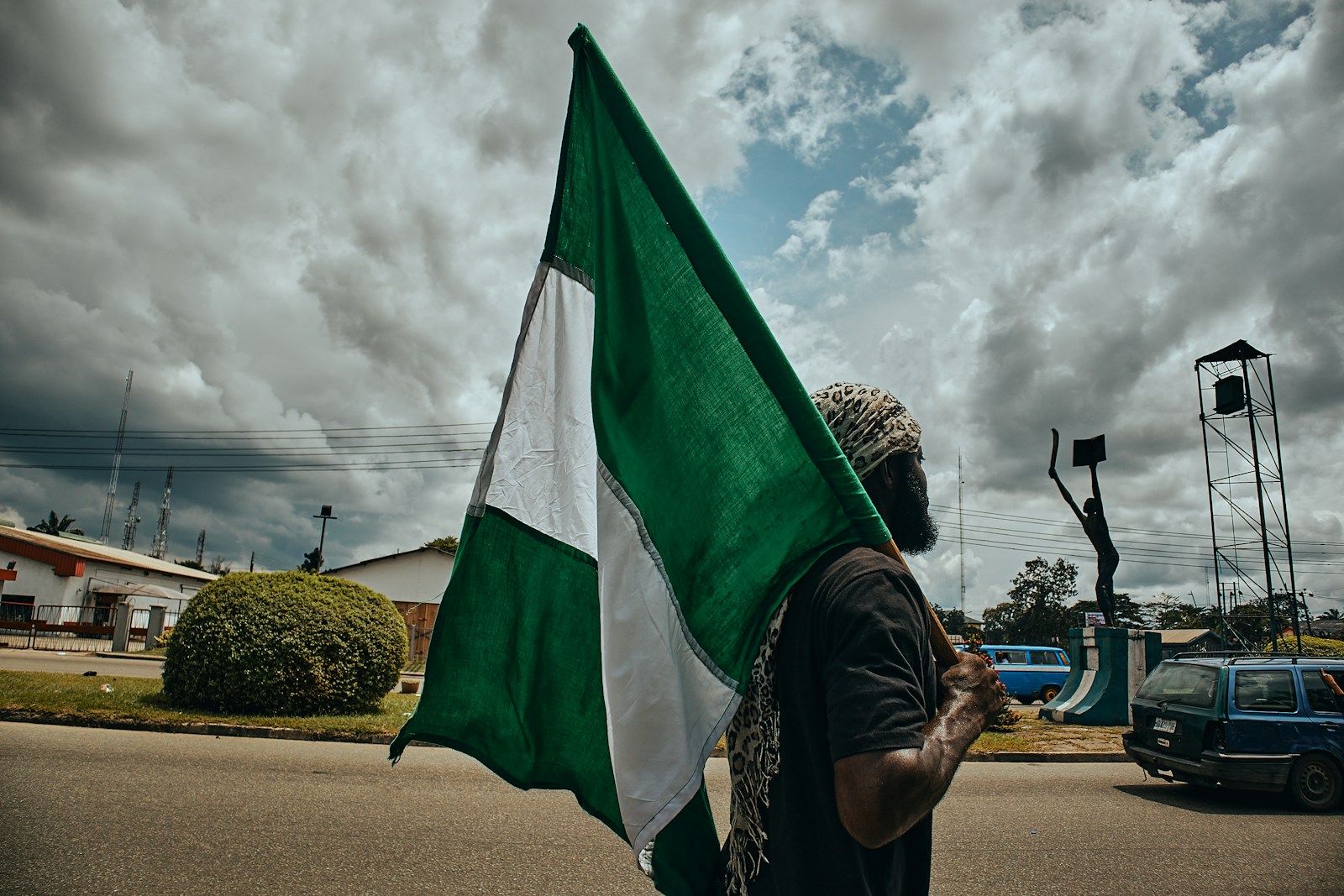 Woman in black and white hijab holding green flag