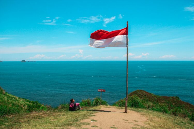 Red and white flag beside beach