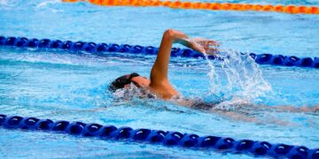 person swimming on an olympic pool
