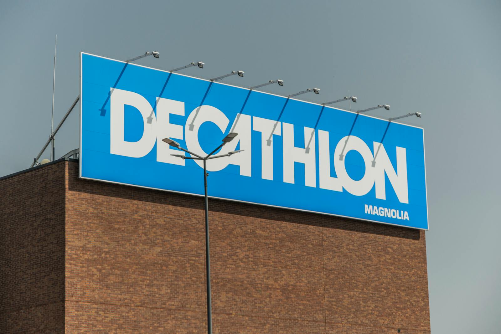 Photo by SHOX art - Info Vandaag Close up of a decathlon store sign against a clear sky on a brick building