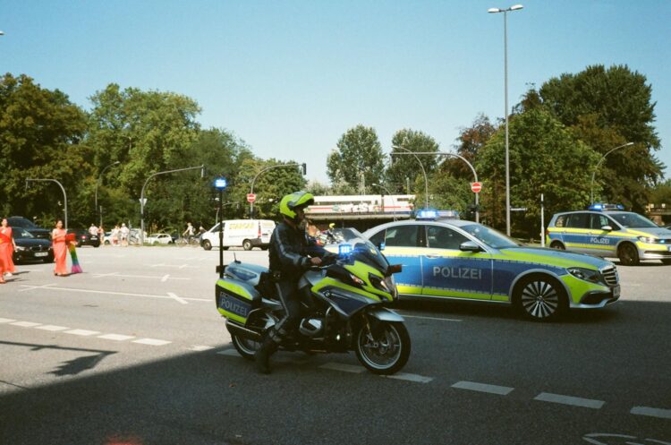 German police presence with cars and motorcycle during daytime traffic control