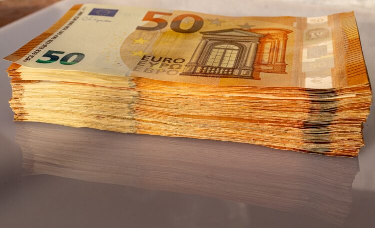 A stack of 50 euro bills sitting on top of a table