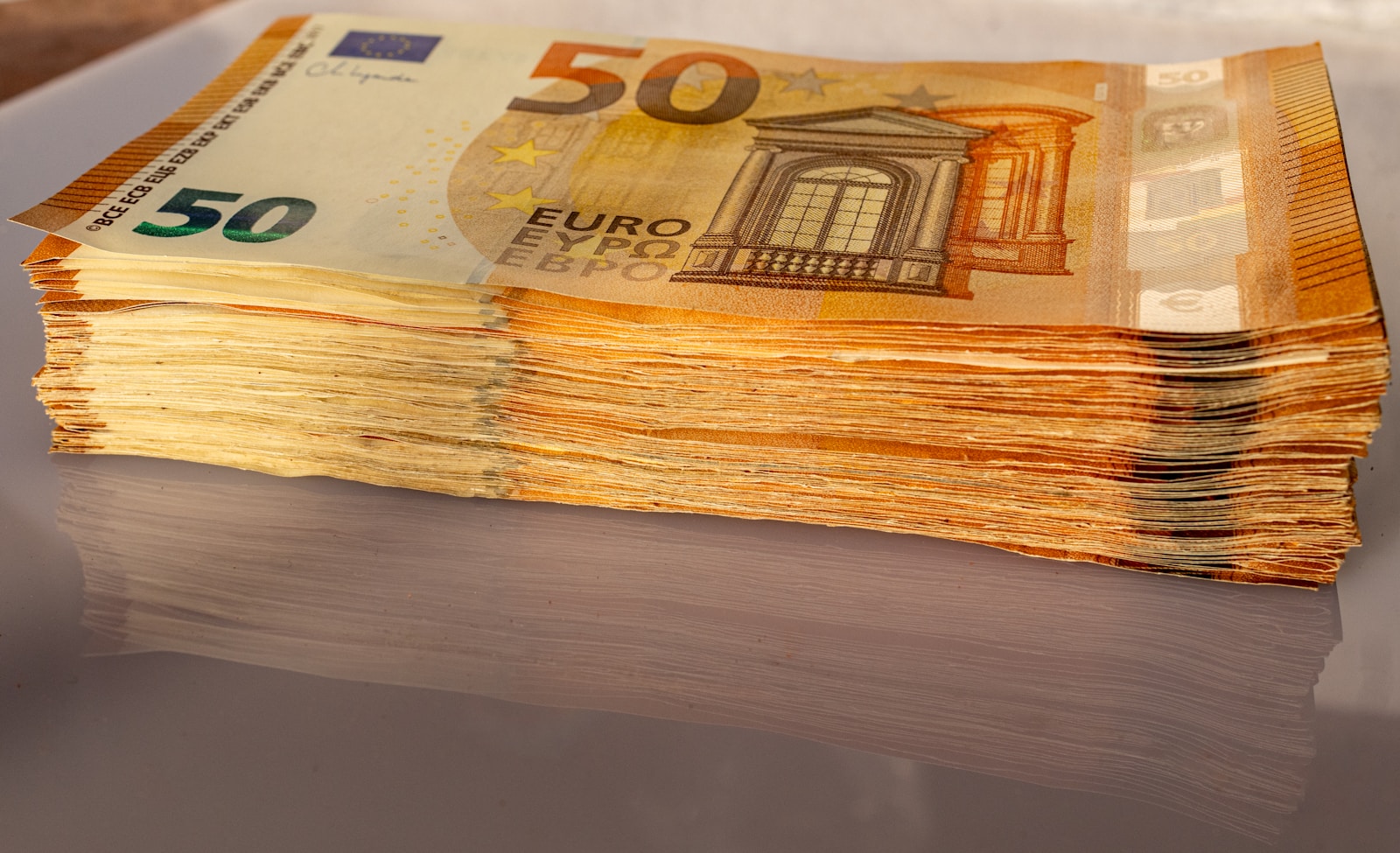 A stack of 50 euro bills sitting on top of a table