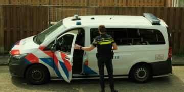 a police officer standing next to a van