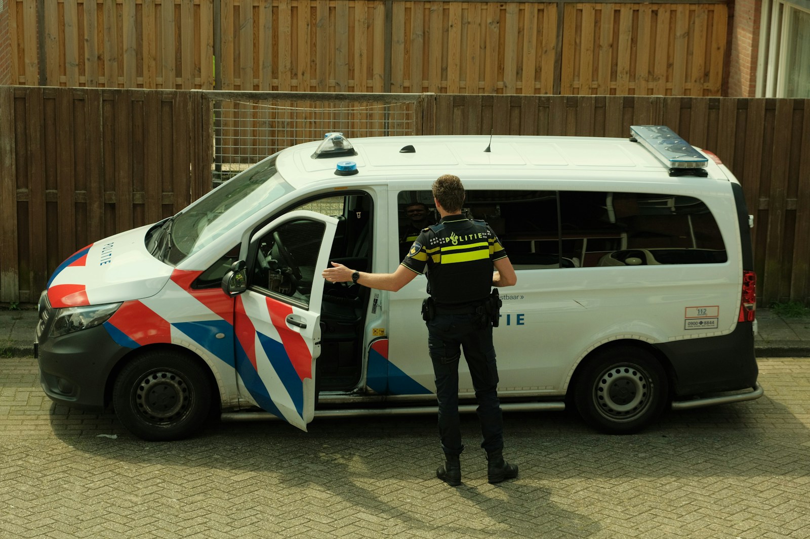 Photo by Kyan Tijhuis - Info Vandaag A police officer standing next to a van