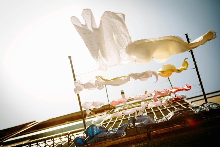 Low angle photography of hanging clothes outside house during daytime