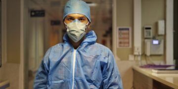 man in blue zip up jacket wearing white cap