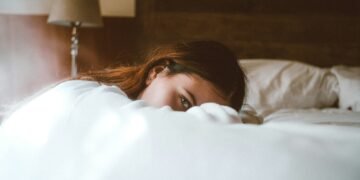 woman resting her head on bed