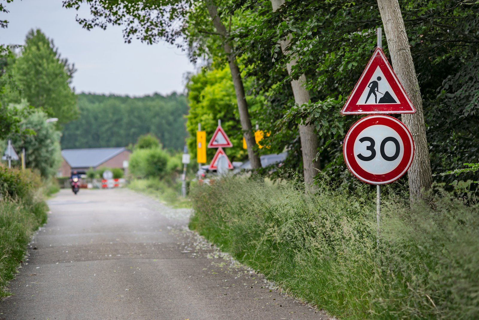 A red and white sign sitting on the side of a road