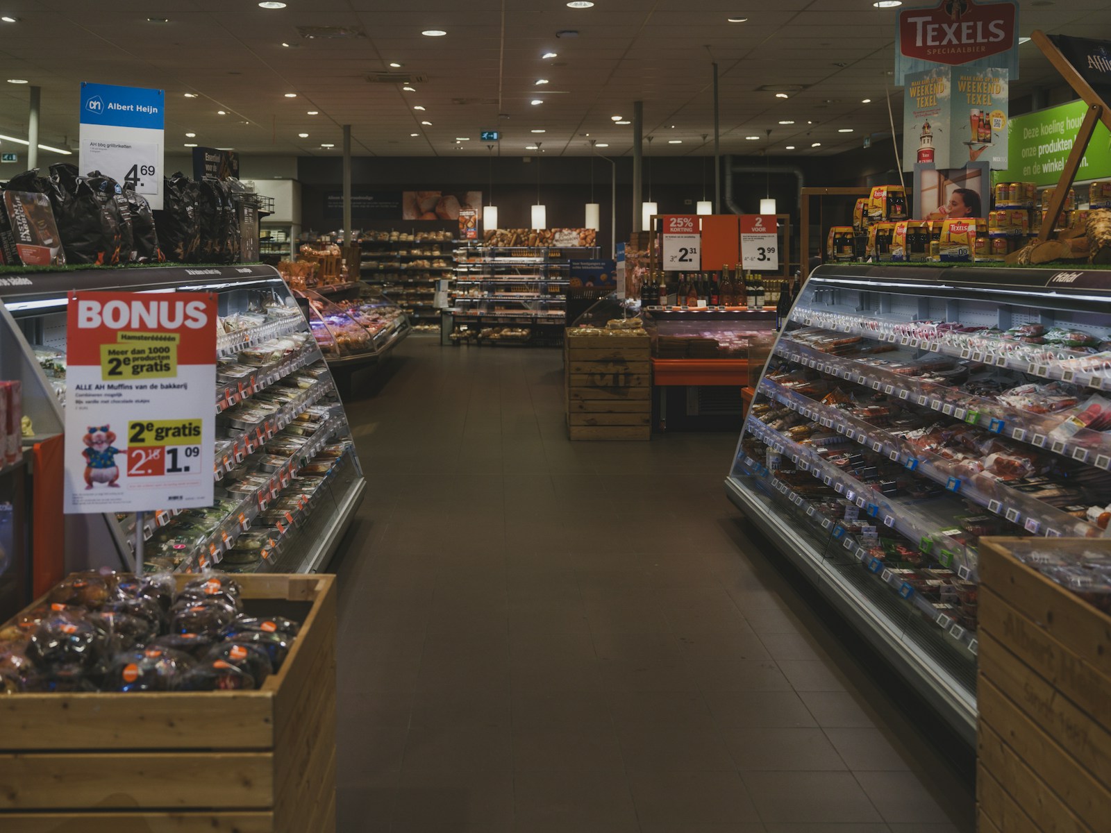 A grocery store aisle with refrigerated food displays