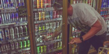 man getting can in beverage cooler