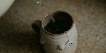a cup of coffee is being filled with water