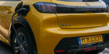 A yellow peugeot ev is being charged.