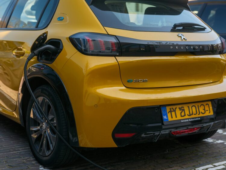A yellow peugeot ev is being charged