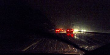Cars driving on a wet road at night