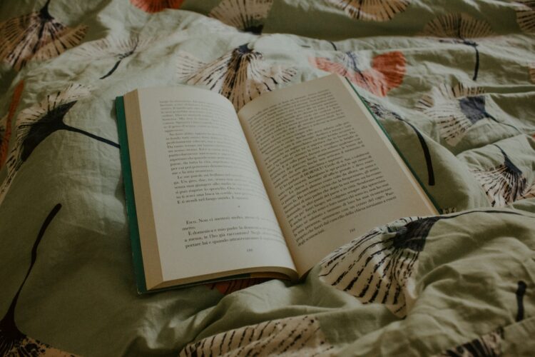 An open book sitting on top of a bed