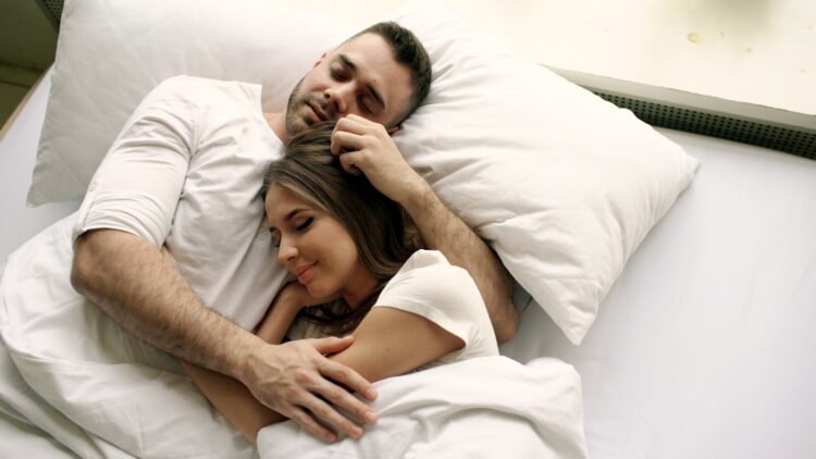 Couple sleeping peacefully in bed together