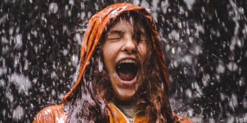 close-up photo of woman in orange coat