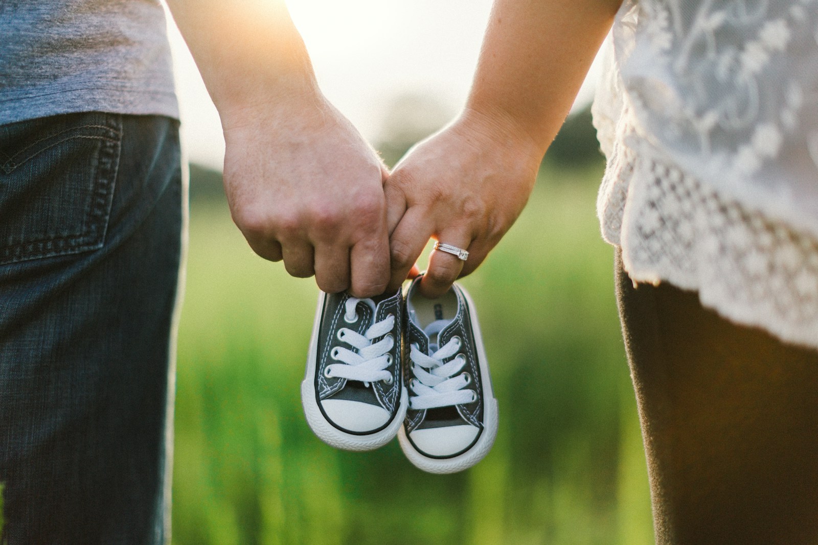 Photo by Drew - Info Vandaag Woman and man holding black crib shoes standing near green grass during daytime