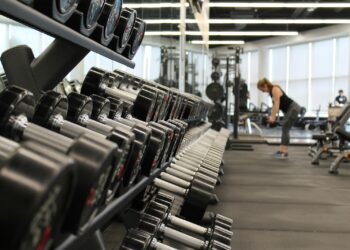 Woman standing surrounded by exercise equipment