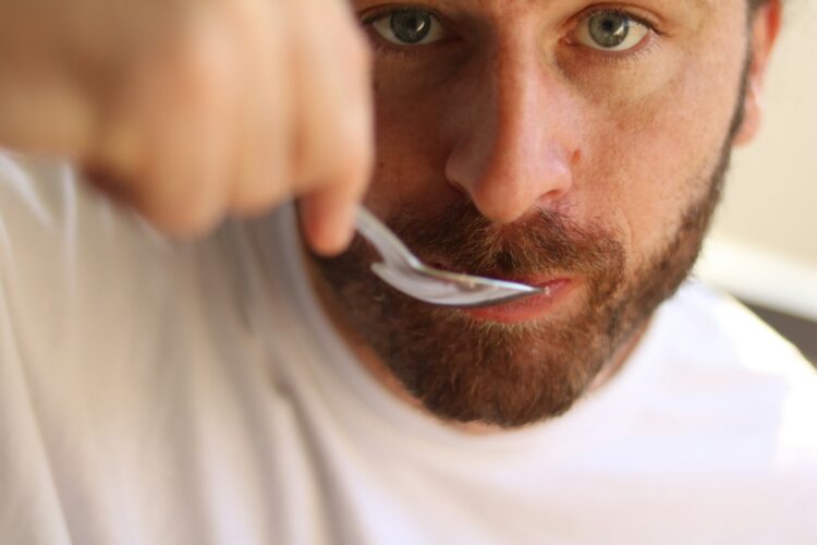 A man is brushing his teeth with a toothbrush