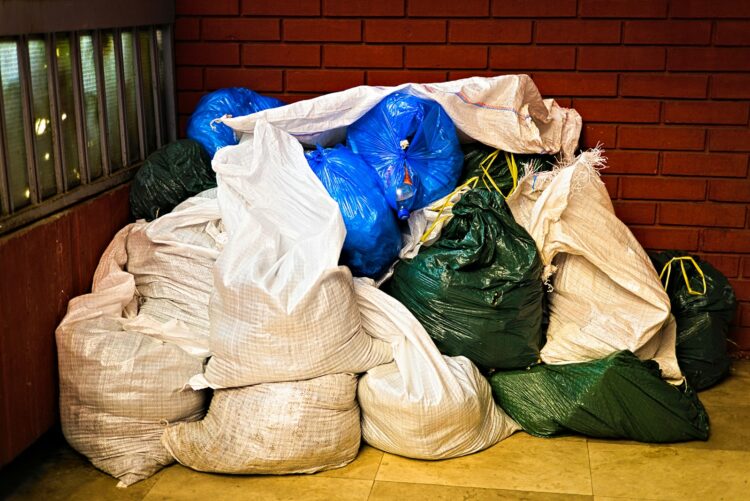 A pile of garbage sitting next to a brick wall