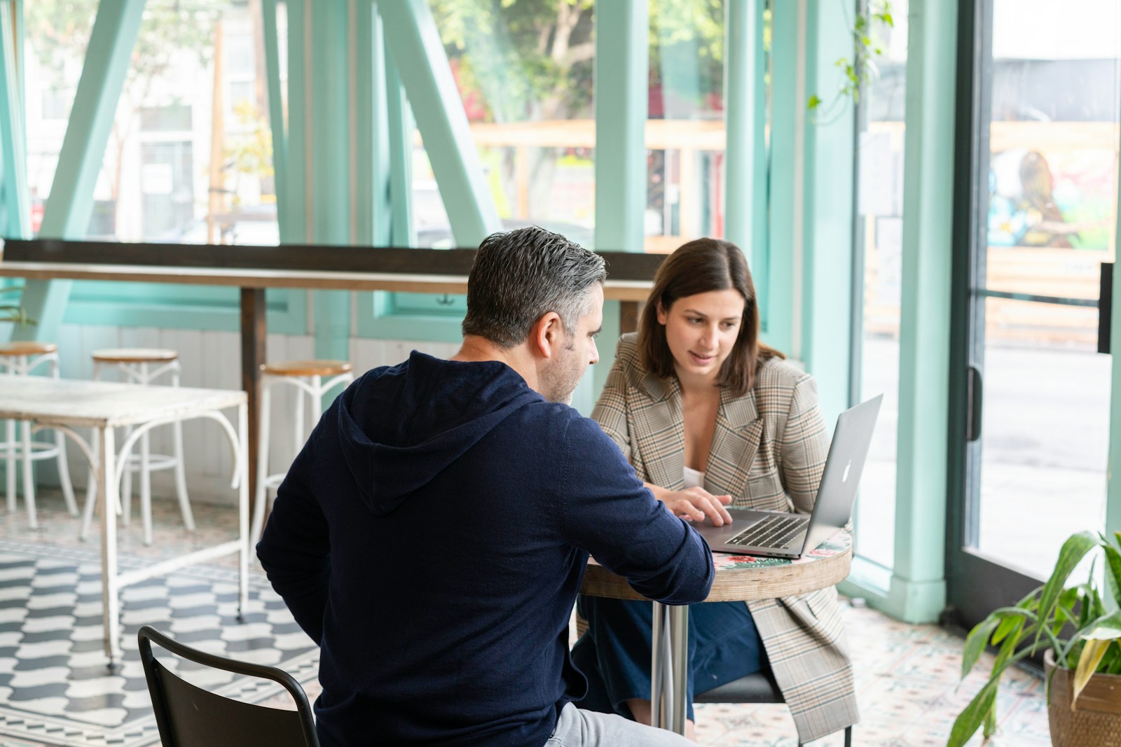 Man in black long sleeve shirt sitting on chair beside woman in black and white stripe