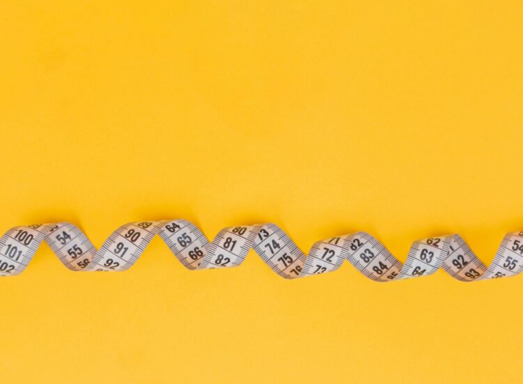 Silver and black necklace on yellow textile