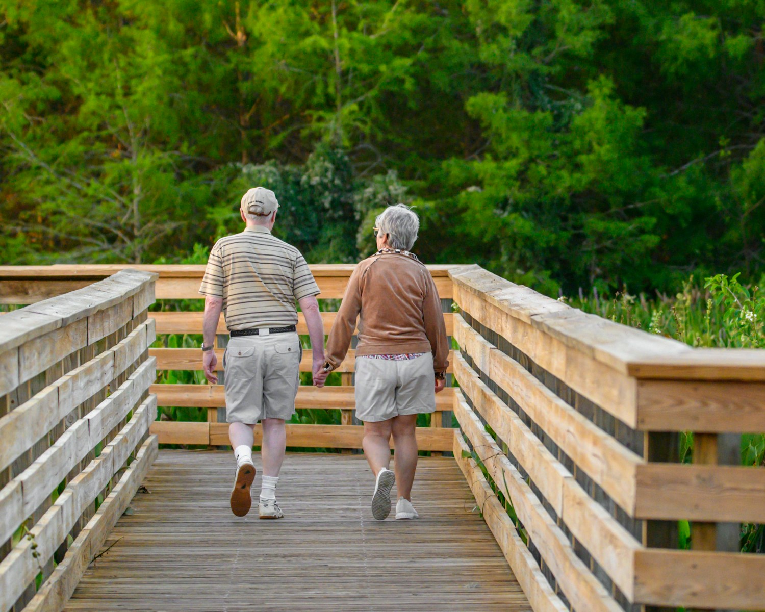A couple of people that are walking across a bridge