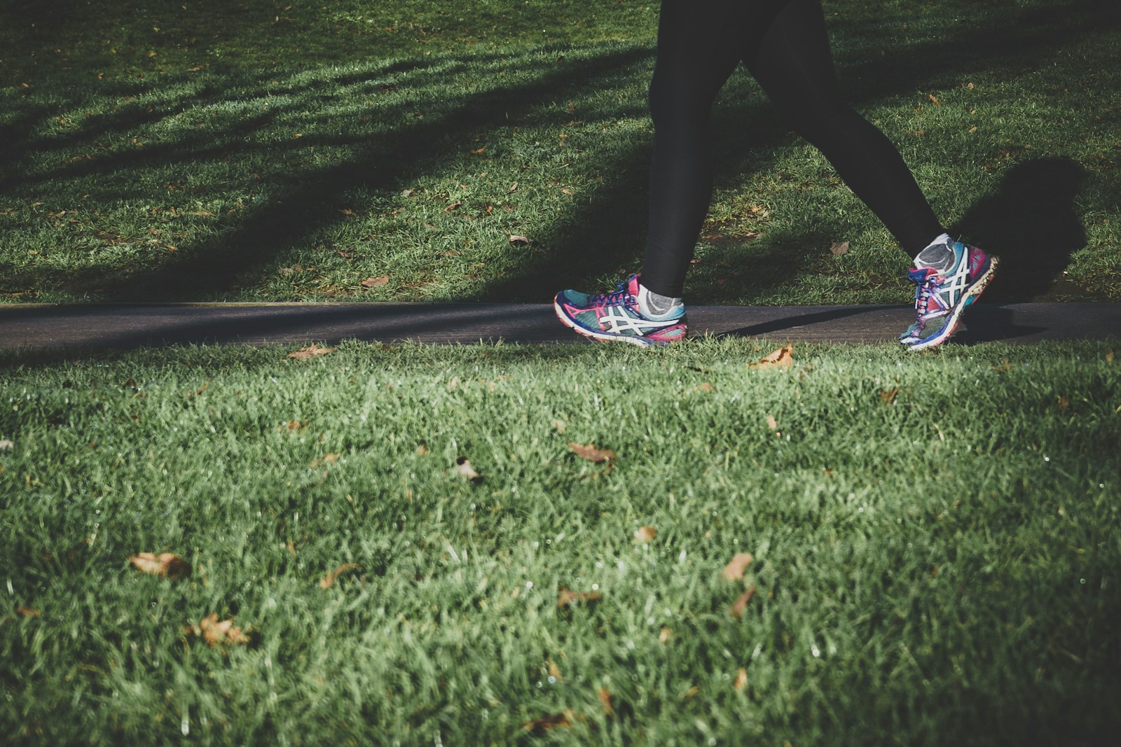 Photo by Arek Adeoye - Info Vandaag Shallow focus photography of person walking on road between grass