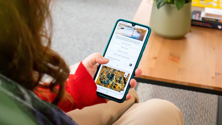 A woman sitting on a couch holding a cell phone