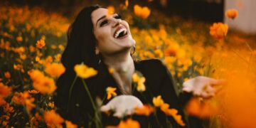 woman laughing on flower field